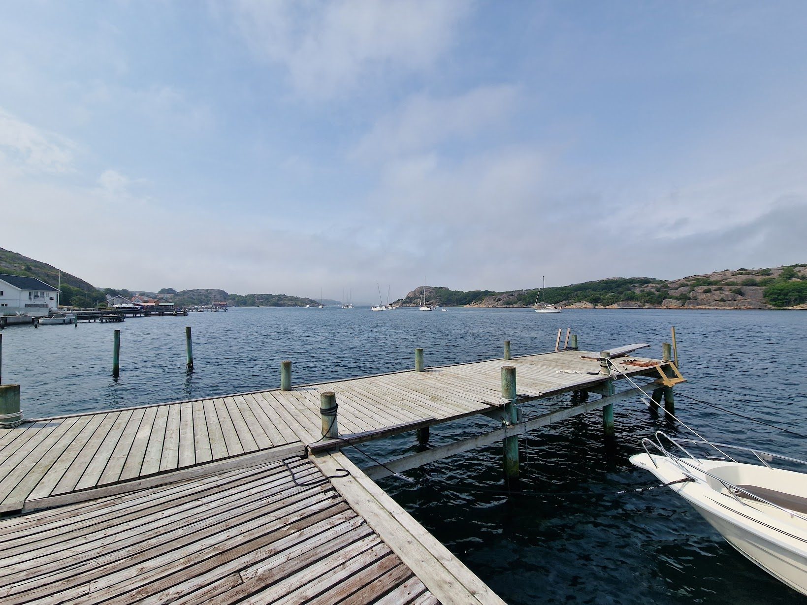 Bryggan med en förtöjd båt och utsikt över sundet